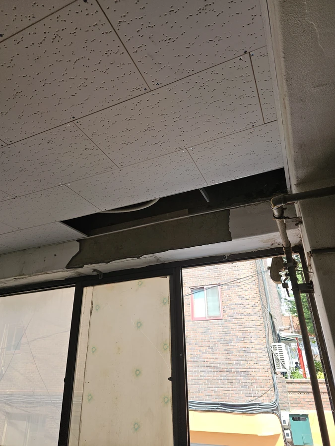 화성시 반지하 천장보수 단열 천장 일부가 열려 배기 덕트와 배관이 보이는 모습