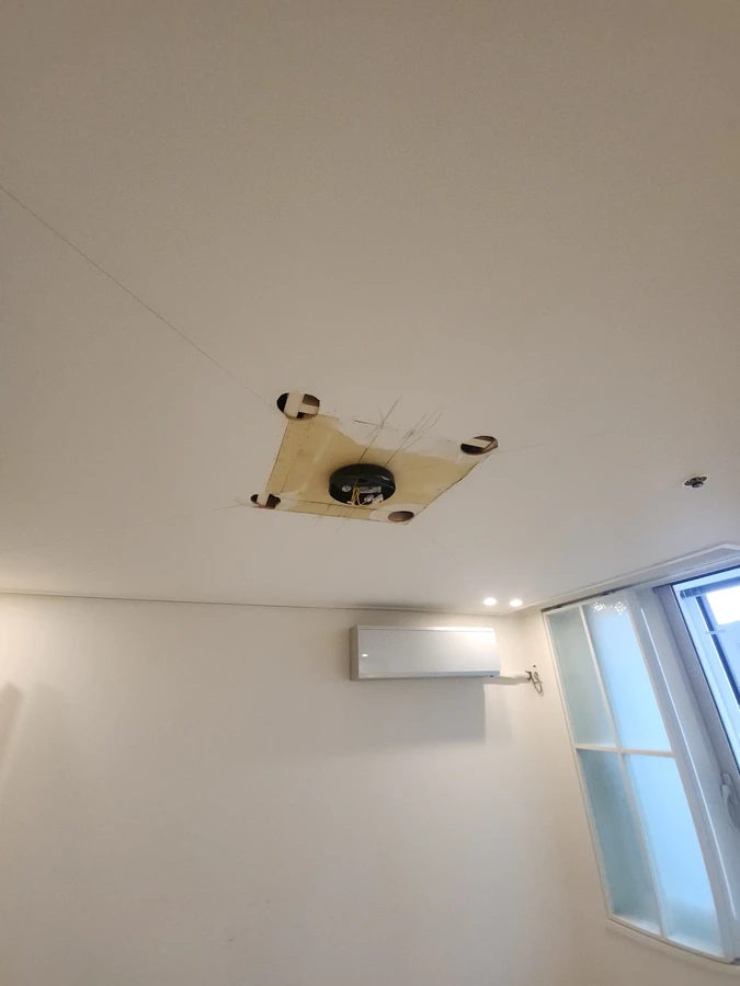 화장실 천장곰팡이 현장 — 점검구 안쪽을 가까이서 찍은 사진으로 합판 배면재 상태와 배선 연결 부위를 확인할 수 있습니다.